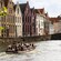 2 boats filled with passengers traveling through a waterway lined with historical buildings